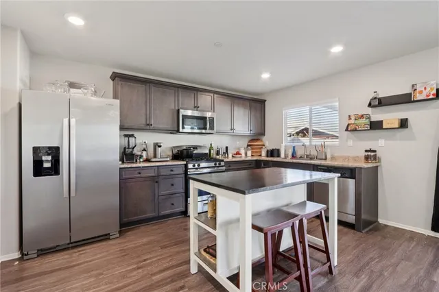 a kitchen with kitchen island granite countertop wooden floors and stainless steel appliances