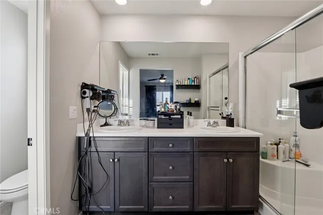 a bathroom with a double vanity sink mirror and shower