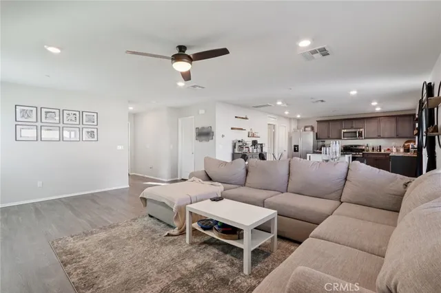 a living room with furniture a large window and wooden floor