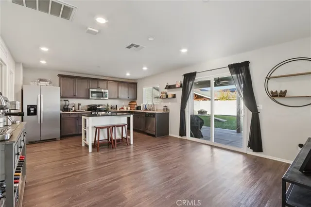a kitchen with stainless steel appliances a refrigerator and a wooden floors