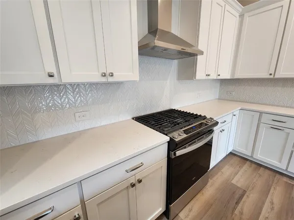 a kitchen with granite countertop white cabinets and black appliances