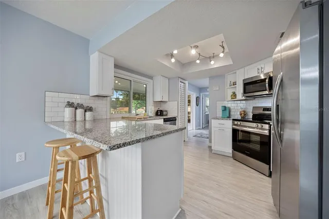 a kitchen with stainless steel appliances granite countertop a stove top oven a sink and dishwasher