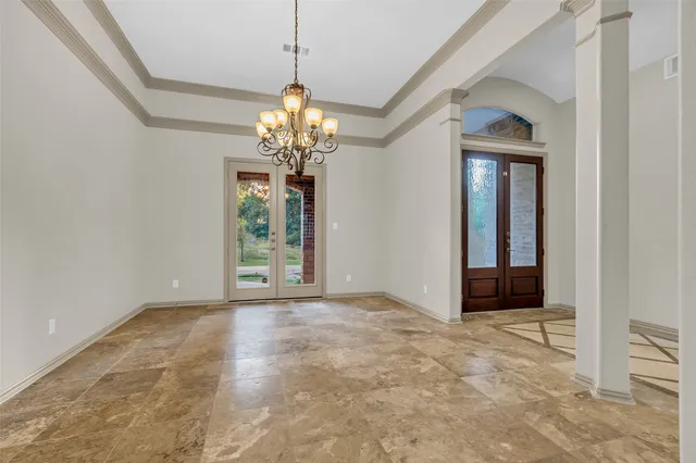 a view of a livingroom with a chandelier curtains and large windows