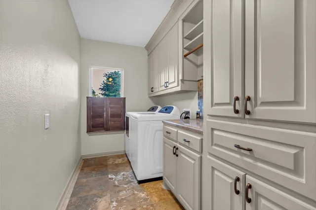 a room with a washer dryer and cabinets