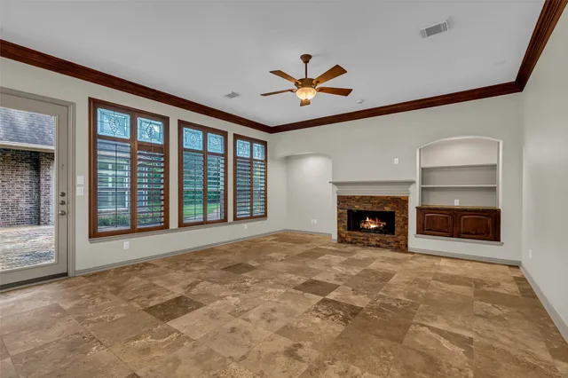 a view of an empty room with a fireplace and a window