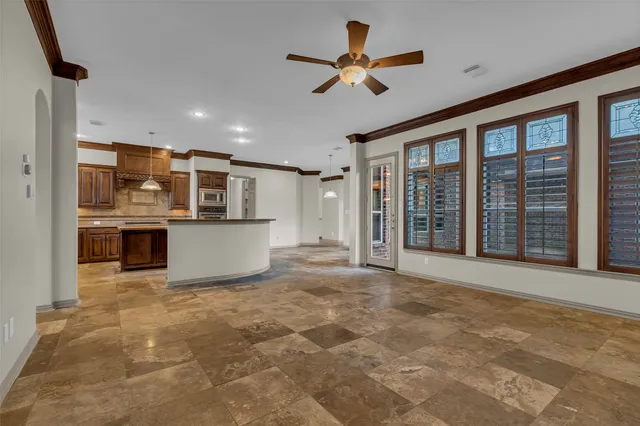 a view of a kitchen with a stove cabinets a ceiling fan and wooden floor