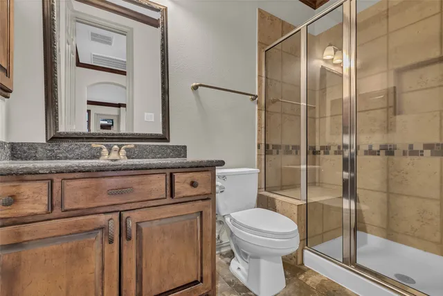 a bathroom with a granite countertop sink toilet and shower