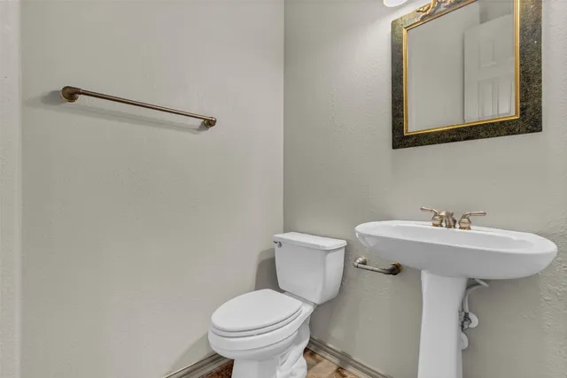 a bathroom with a sink mirror and toilet