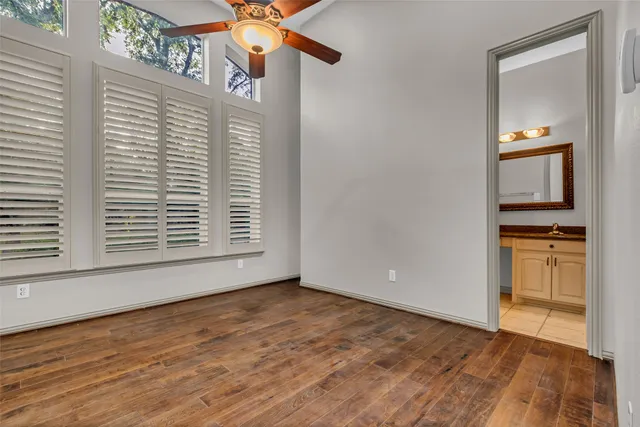 a view of empty room with kitchen and wooden floor