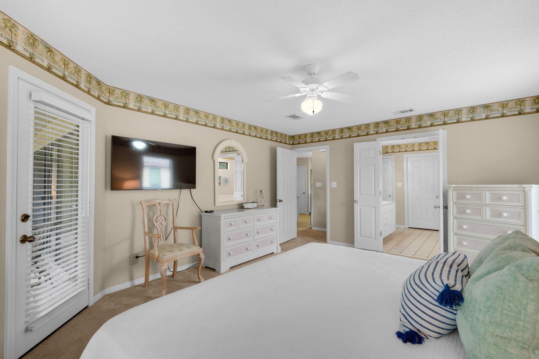 77 Golf Tee Lane, Unit 27G Miramar Beach, FL 32550 - Photo 12 of 29 a bedroom with a bed and a chandelier