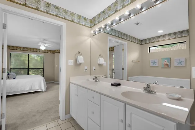 a spacious bathroom with a double vanity sink mirror and bathtub