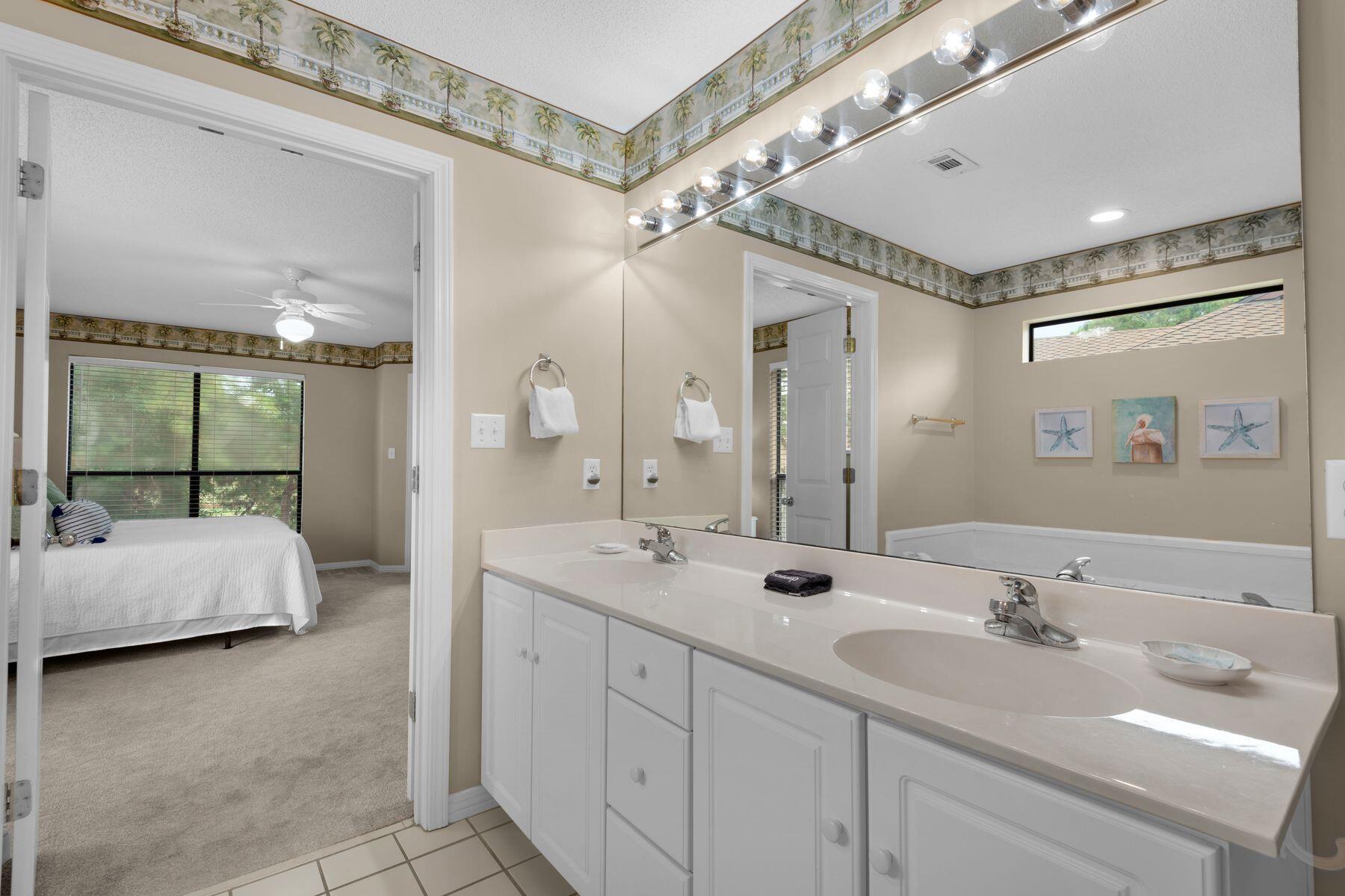 77 Golf Tee Lane, Unit 27G Miramar Beach, FL 32550 - Photo 14 of 29 a spacious bathroom with a double vanity sink mirror and bathtub