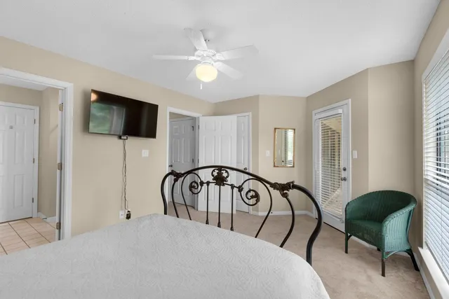 a bedroom with a bed a mirror and a flat tv screen