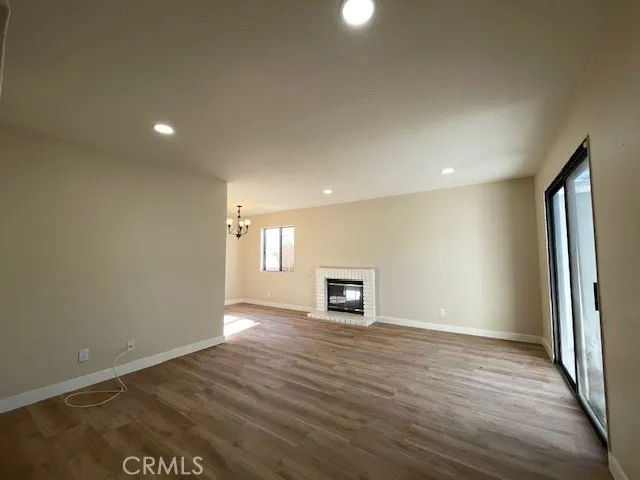 an empty room with wooden floor and a fireplace