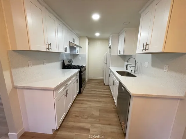 a kitchen with a sink a stove a refrigerator and cabinets