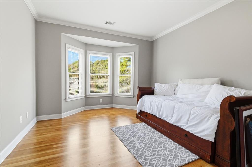 1607 Oak Grove Road Decatur, GA 30033 - Photo 28 of 71 a spacious bedroom with a bed and wooden floor