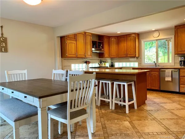 a kitchen with a stove a sink a dining table and chairs