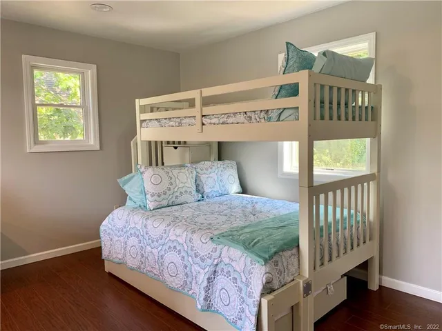 a bedroom with a bed next to a window