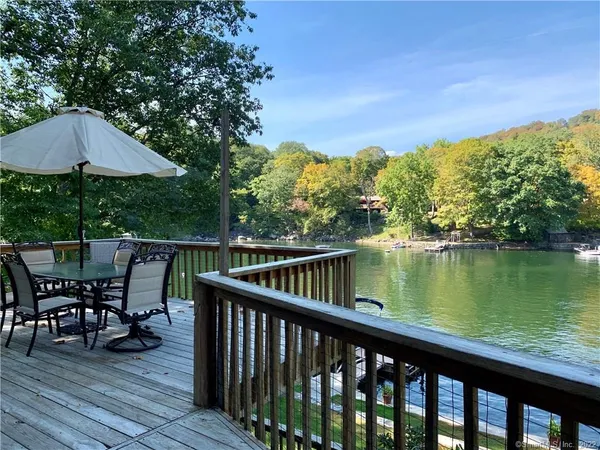 a balcony with wooden floor table and chairs