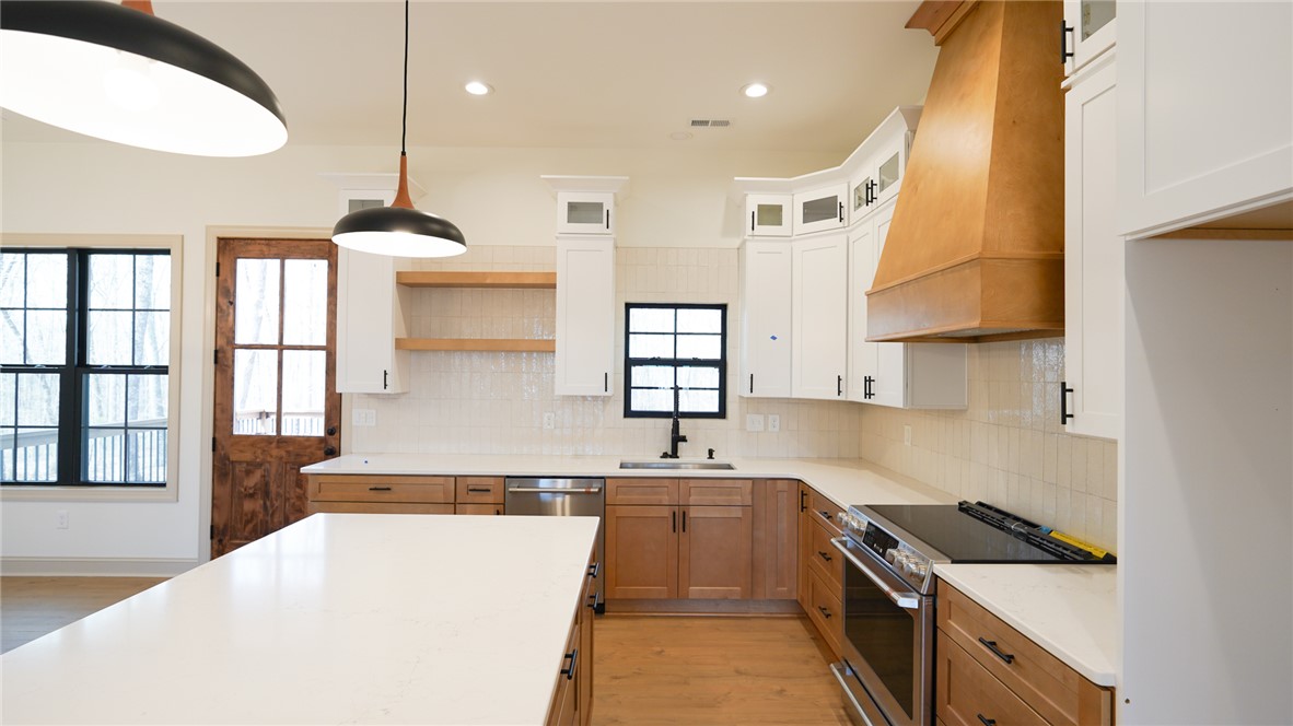1001 Five Forks Road Pendleton, SC 29670 - Photo 12 of 43 This kitchen features a bright ambiance, practical island, and classic wood flooring.