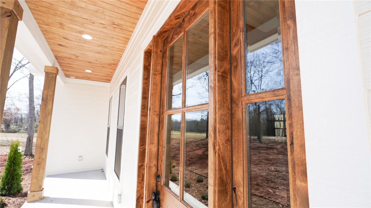 1001 Five Forks Road Pendleton, SC 29670 - Photo 4 of 43 This porch features a wooden plank ceiling and sturdy wood columns, offering a welcoming entrance.