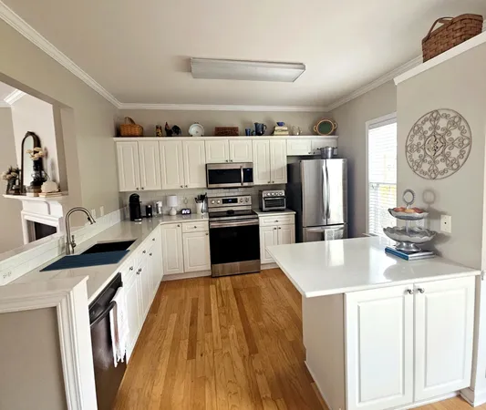 a kitchen with kitchen island a counter appliances a sink and a stove