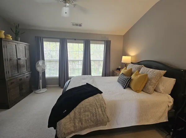 a bedroom with a bed and a refrigerator