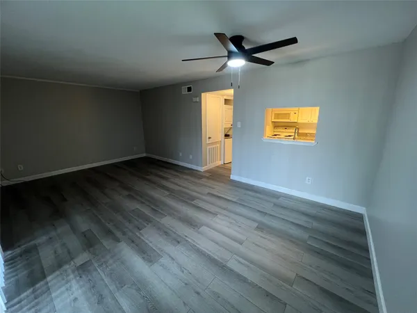 a view of empty room with wooden floor