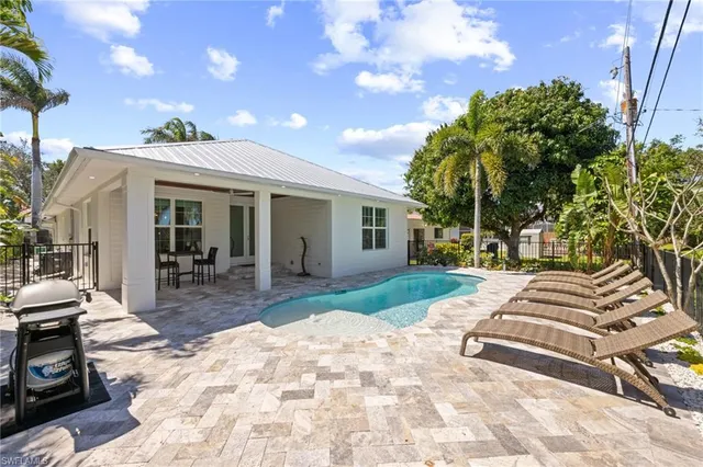 a view of a house with backyard and sitting area