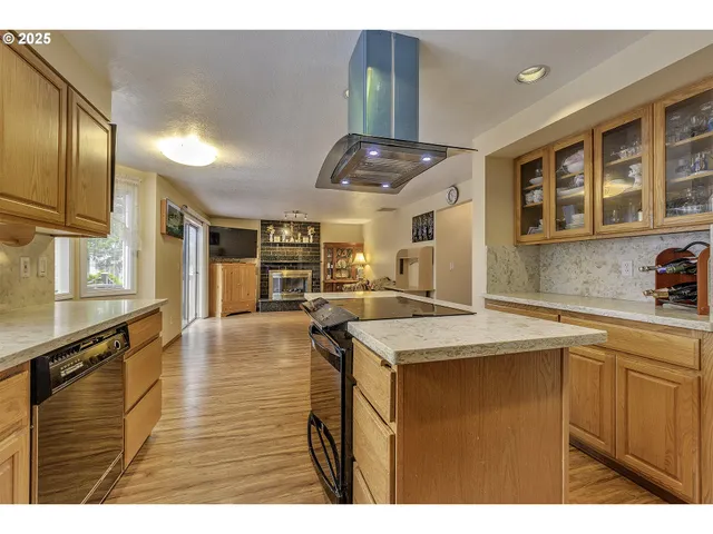 a kitchen with stainless steel appliances granite countertop a sink a stove counter space and cabinets
