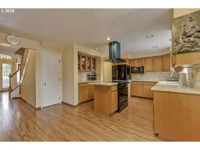 a kitchen with a sink cabinets and wooden floor
