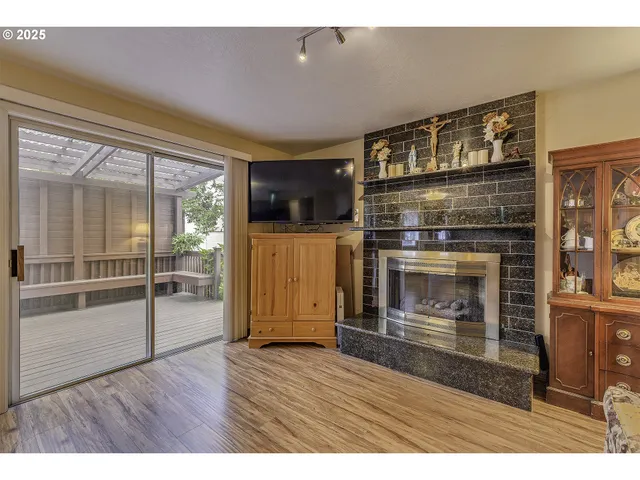 a open kitchen view with wooden floor a fireplace and a window