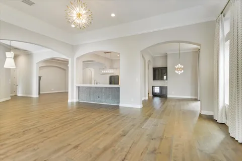 a view of a big room with wooden floor and a kitchen
