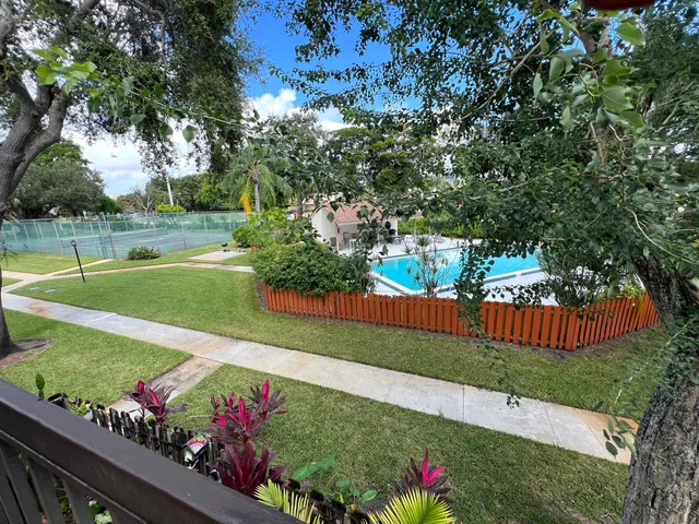 a view of a garden with flowers and wooden fence