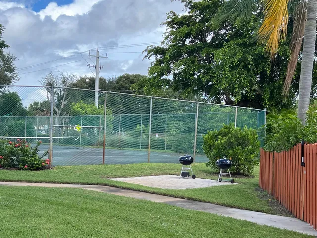 a view of a backyard with plants and wooden fence