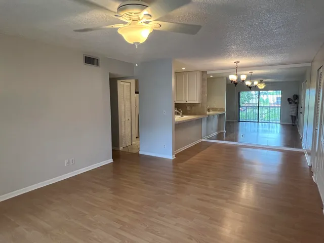 an empty room with wooden floor and chandelier