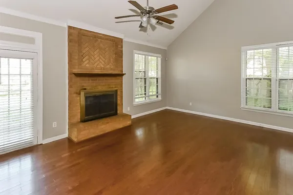 a view of a livingroom with furniture a fireplace and wooden floor
