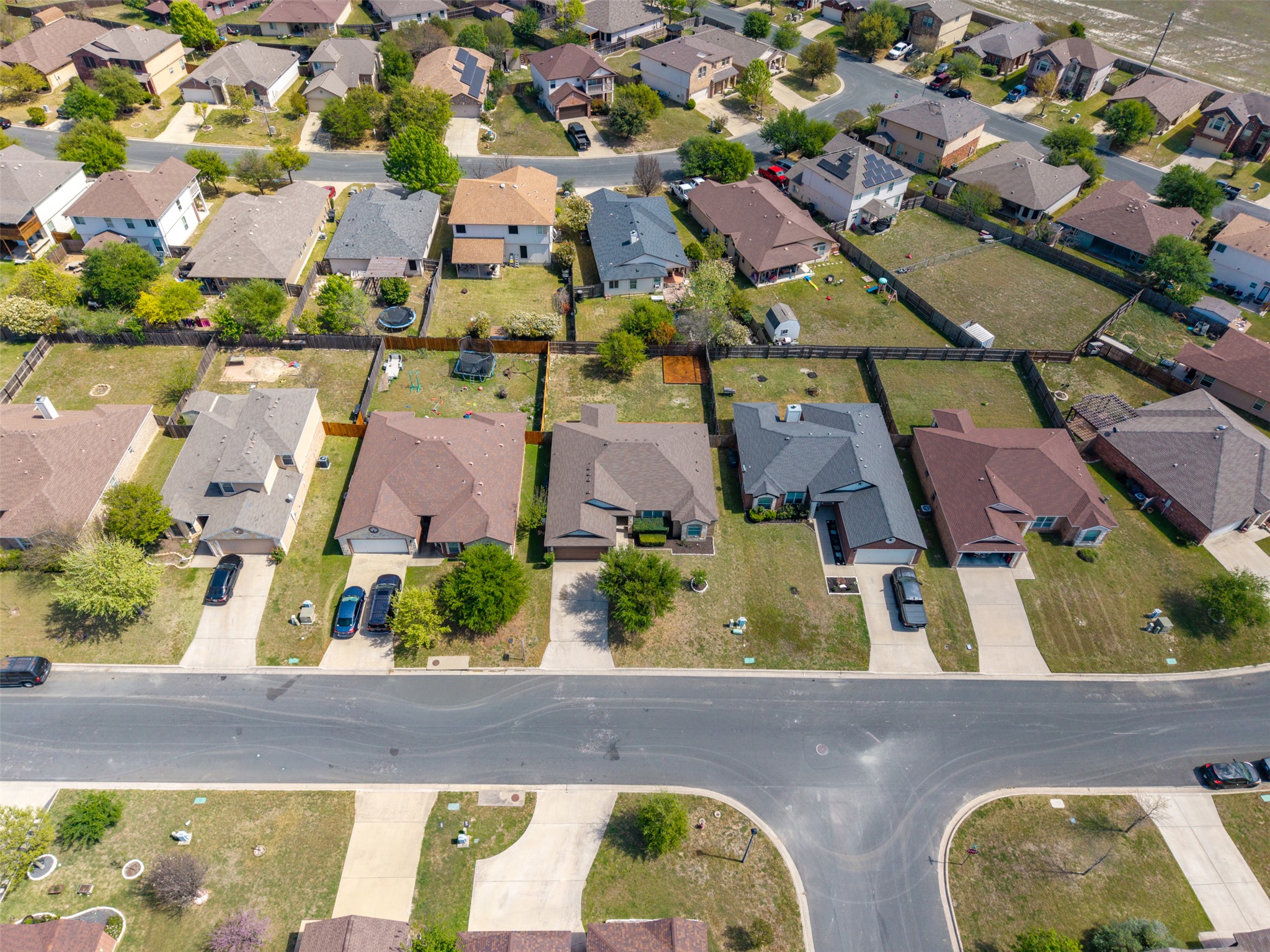 133 Lignite Drive Jarrell, TX 76537 - Photo 29 of 36 The full lot is visible here, showcasing the backyard space, covered patio, and the corner built patio area all in one view.