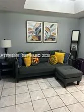 a living room with furniture and wall paintings