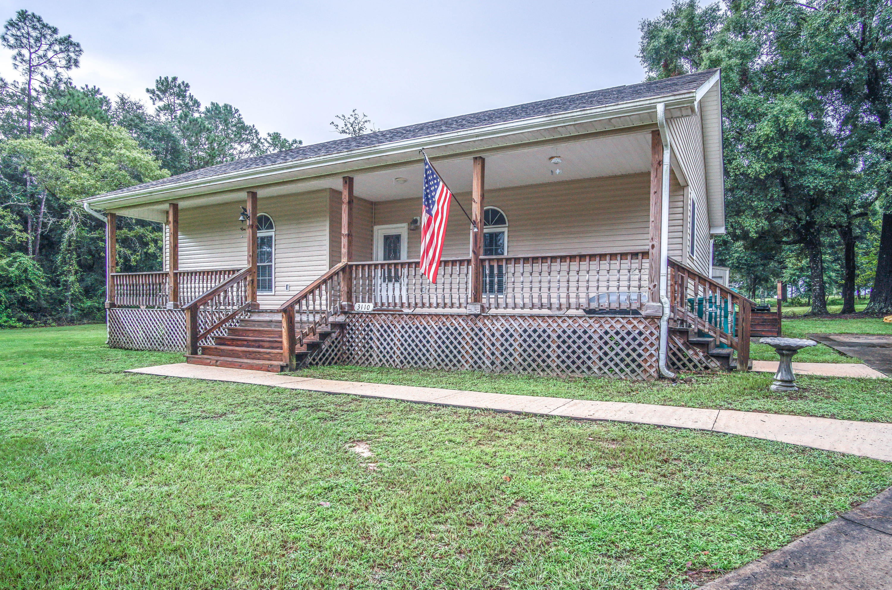 3110 Bay Ridge Drive Crestview, FL 32539 - Photo 24 of 31 a view of a house with a small yard and a large tree