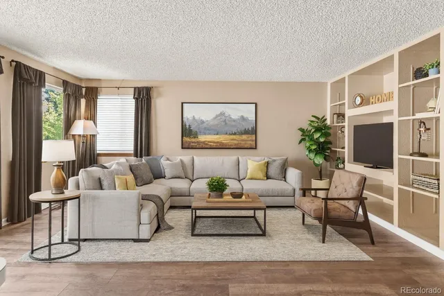 a living room with furniture a flat screen tv and a large window