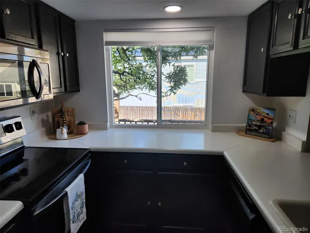 a kitchen with granite countertop a sink stove and cabinets
