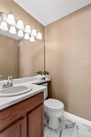 a bathroom with a sink a toilet and a mirror