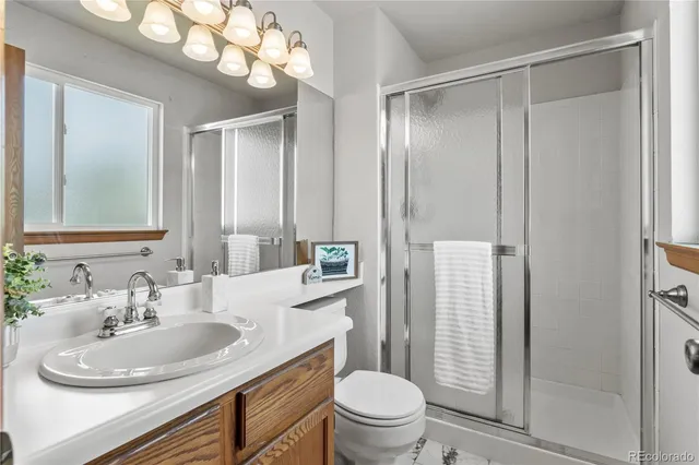 a bathroom with a sink toilet a mirror and shower