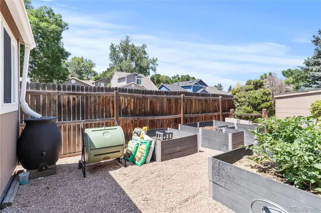 a view of a chair and tables in the back yard of the house