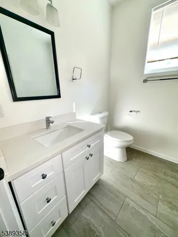 a bathroom with a double vanity sink mirror and toilet