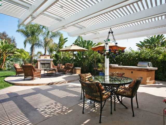 a view of a patio with a table and chairs under an umbrella