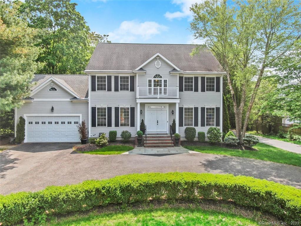 a front view of a house with a yard and green space
