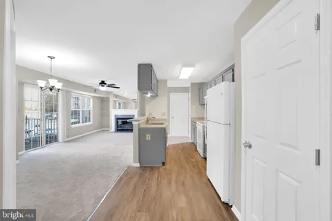 a view of a kitchen with wooden floor and a refrigerator