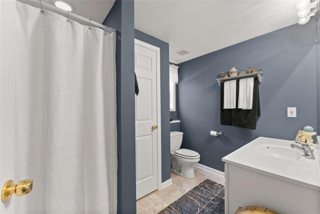219 John Garner Road Dahlonega, GA 30533 - Photo 45 of 76 a bathroom with a granite countertop sink toilet and shower curtains